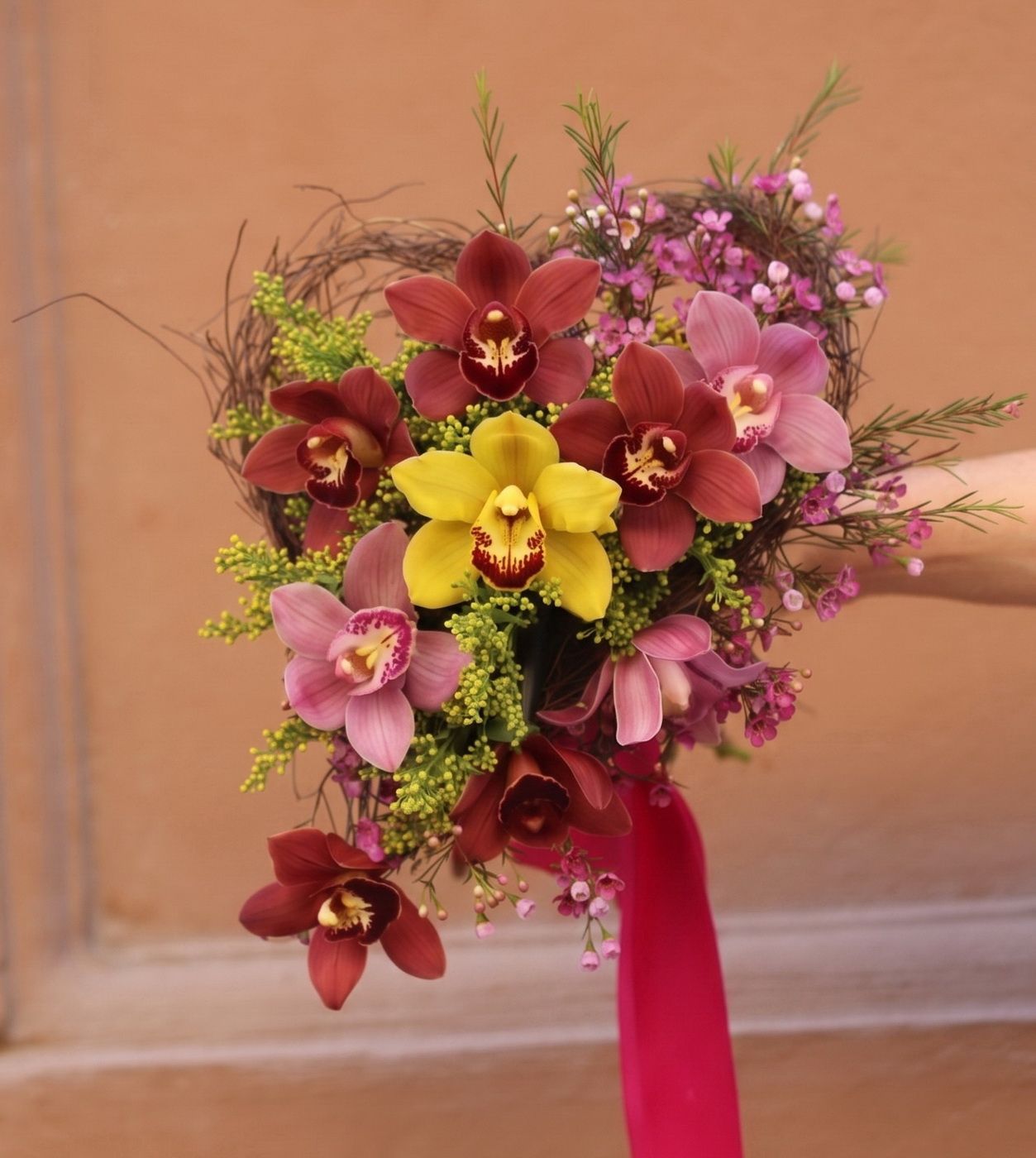 Blumenlieferung nach Budapest - Farbenfrohe Orchideen in einem kleinen herzförmigen Strauß (9 Blüten)