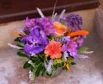 Small colorful summer flower arrangement in modern pot, with orchid 