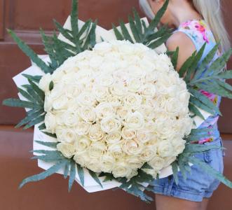 ein Strauß aus 100 weißen Rosen mit Grün und Geschenkpapier