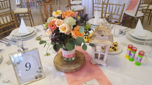 Wedding table decoration on wooden disc with lantern, Szent Anna Fogadó Berkenye (spray rose,rose, wild flowers, peach)