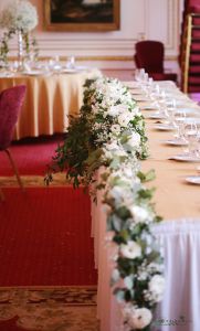 Main table centerpiece with flower garland Gundel (lisianthus, babybreath, ruscus, white)
