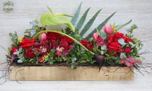 Modernes Arrangement in Holzkiste, mit roten Rosen und Orchideen