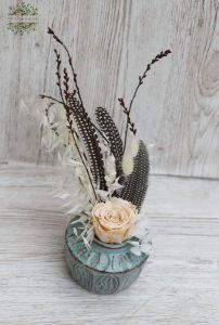 peach eternal rose in a blue vase with feathers