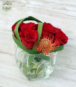 Moderner Glaswürfel mit 7 roten Rosen und Leukospermum