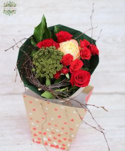 kleiner Strauß roter Rosen in einer tragbaren Blumentasche mit Henkeln