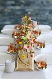 Modern fiolás asztaldísz esküvőre, rendezvényre (csipkebogyó, orchidea, kála, anthurium, rózsaszín, barack, piros)