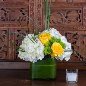 Glasskubus mit Hortensien und Gelben Rosen (4 Rosen, 2 Hortensien, Grüne Pompoms)