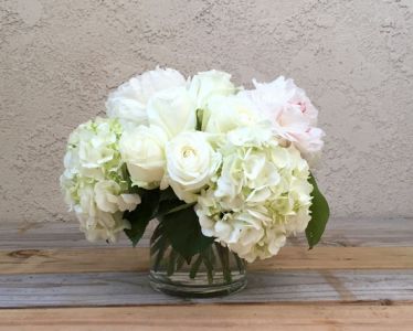 Glaskugel mit weißen Rosen und Hortensien