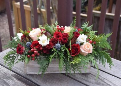 Tischdekoration mit Rosen, Lisianthus und Mannstreu.