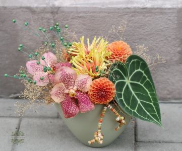 Herbstliche Komposition mit Vanda-Orchideen und Anthurieblättern