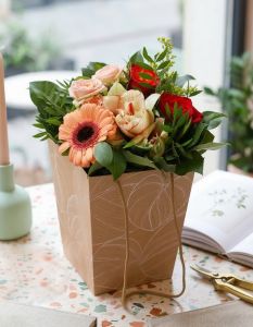 small peach-red bouquet in a portable flower bag with ears