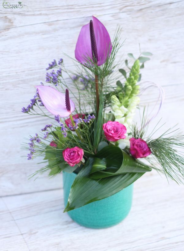 Centerpiece with purple anthuriums, spray roses