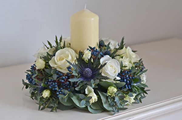 Centerpiece with dark blue eryngium and berries and candle