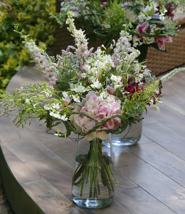 Table decoration in a vase (hydrangea, delphinium, wild flowers, pink, white)