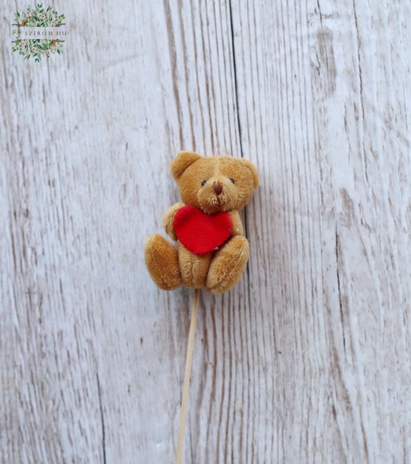 brown teddybear with a heart on a stick
