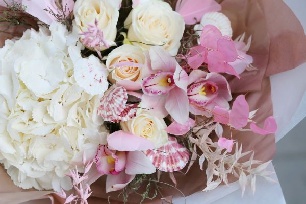 Pastel pink summer bouquet with seashells, orchids