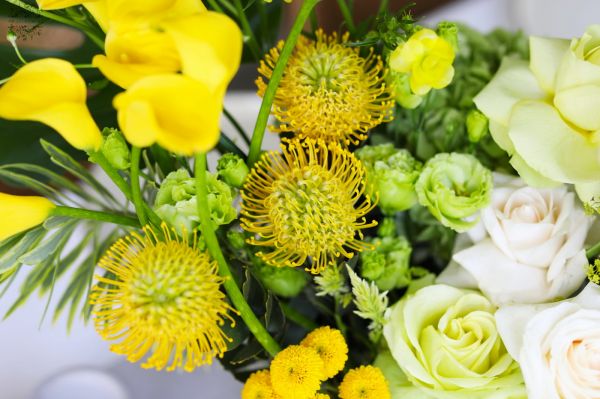 Large wedding event table decoration or centerpiece, crescent-shaped (yellow, calla, rose, leucospermum, lisianthus, English rose)