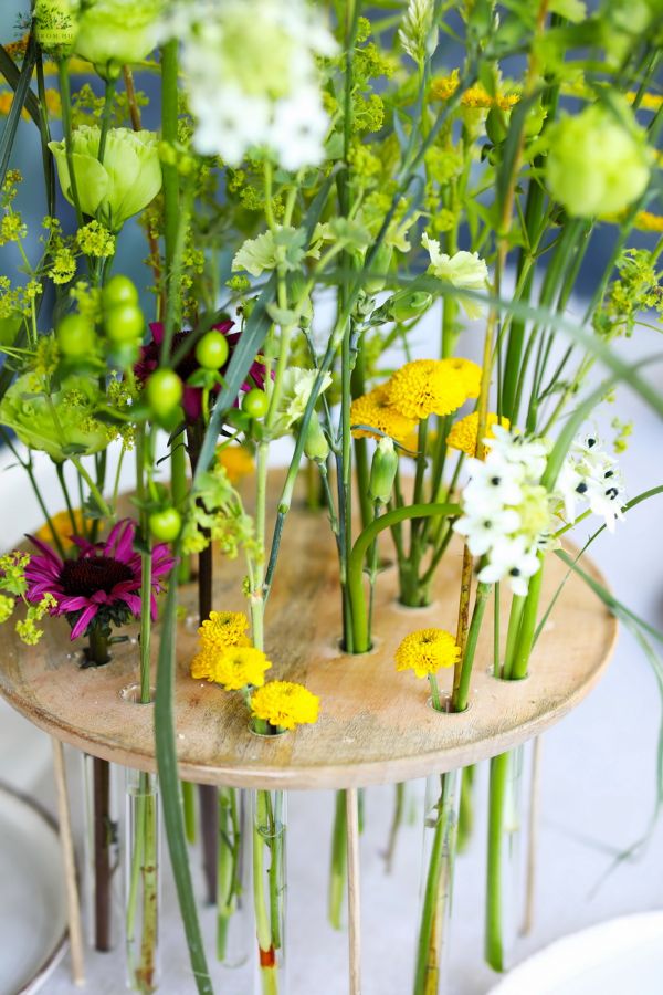 Airy modern wedding and event table decoration with field-like flowers, in a vial base (yellow, orithogalum, lisianthus, chrysanthemum, seasonal flowers)