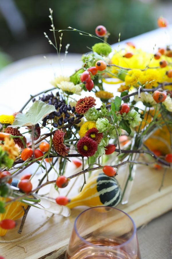 Modern wedding table decoration with vials and autumn flowers (chrysanthems, orange, yellow, burgundy)