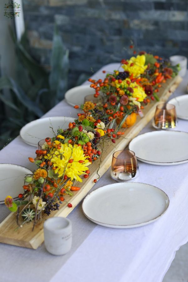 Modern wedding table decoration with vials and autumn flowers (chrysanthems, orange, yellow, burgundy)