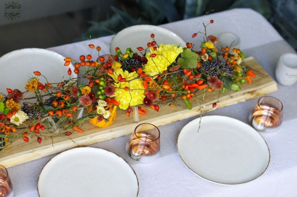 Modern wedding table decoration with vials and autumn flowers (chrysanthems, orange, yellow, burgundy)