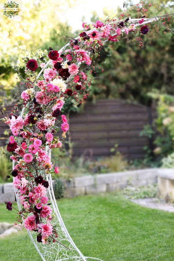 Asymmetrical wedding gate arch with dahlias, zinnias, seasonal berries (pink, burgundy, red)