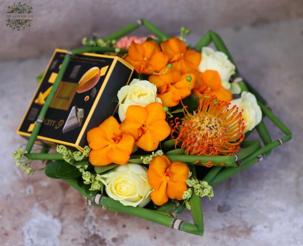 Blumenschale mit Pralinen und Orchideen