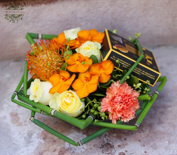 Blumenschale mit Pralinen und Orchideen