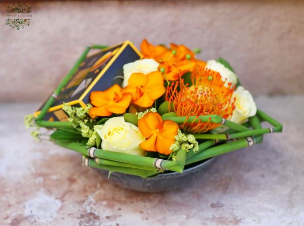 Blumenschale mit Pralinen und Orchideen