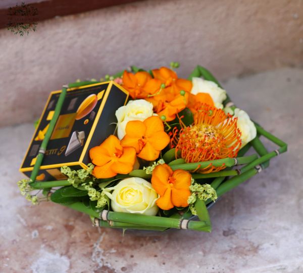 Blumenschale mit Pralinen und Orchideen