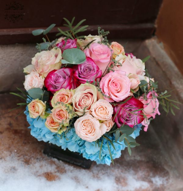 Gesteckte Blumen mit Hortensien und Rosen in einem Glaswürfel