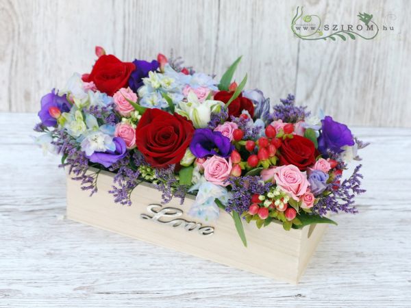 Blumengesteck in einer Holzkiste (Rose, Delphinium, Sprayrose, Hypericum Beeren, Blau, Rot)