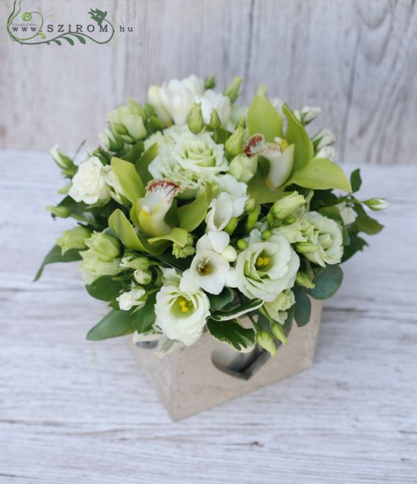 Blumenarrangement in einer Holzkiste (Lisianthus, Orchidee, Freesie, weiß, grün)