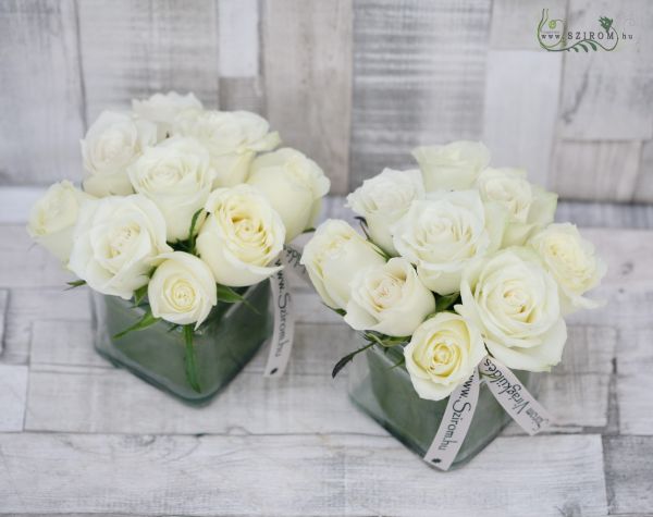Blumenarrangement in einem Glaswürfel mit weißen Rosen