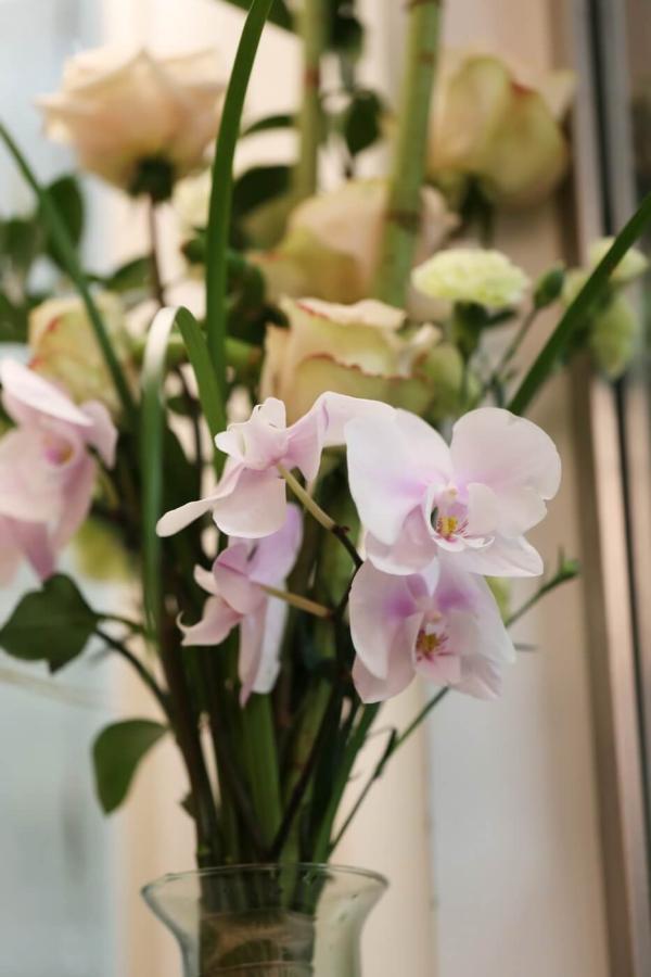 Orientalischer Rosenstrauß mit Orchideenstiel, Vase