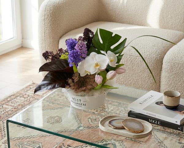 Saubere, moderne Blumenschale mit Tulpen, Hyazinthen, Orchideen und besonderen Blättern - original product photo with AI background