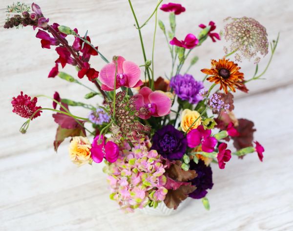 Wildblumen und Orchideen in einer Keramiktopf