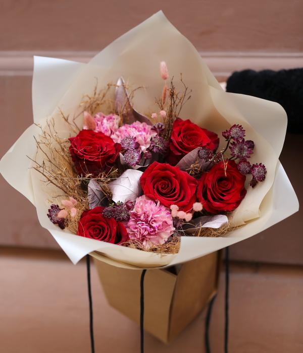 Red rose bouquet in bag with water, in theme of the color of the year Mocha Mousse