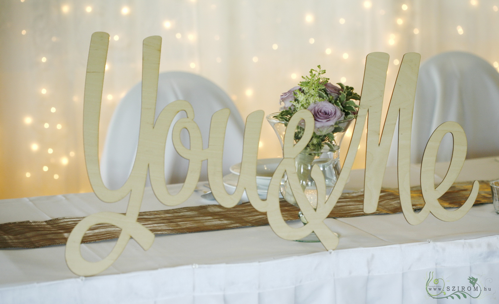 flower delivery Budapest - wooden You and Me table decor, light backdrop , Bagolyvár, wedding