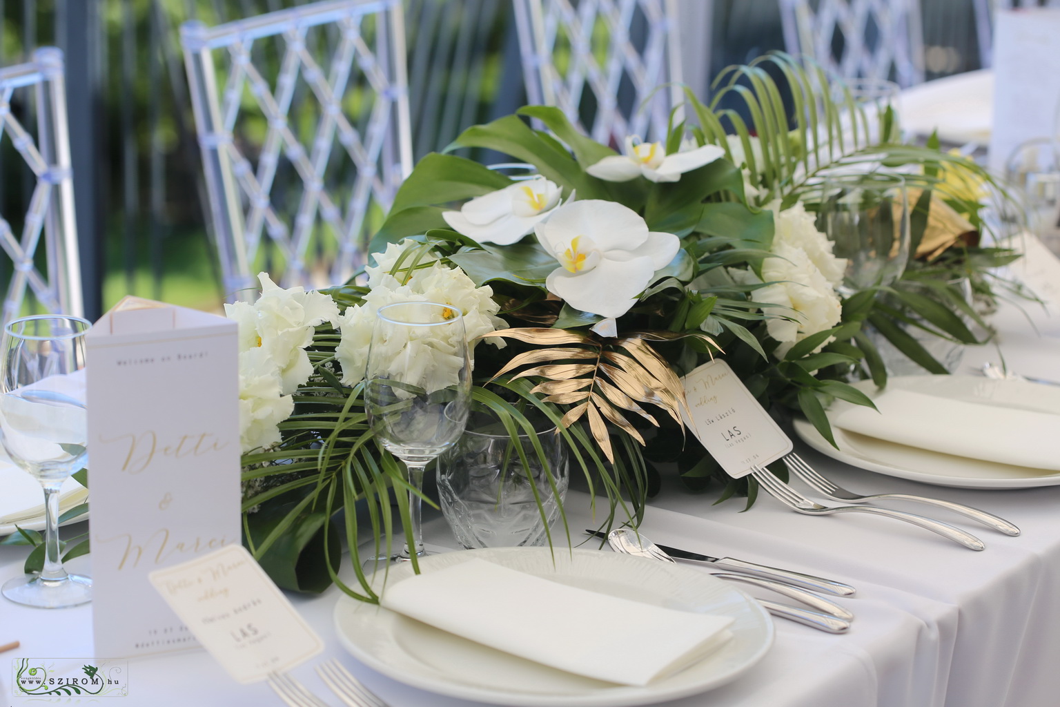 flower delivery Budapest - Elongated wedding centerpiece, Bazaar Eclectica Café and Restaurant Budapest  (Phalaenopsis orchid, lisianthus, monstera leaf, palm leaf, white, green, gold)