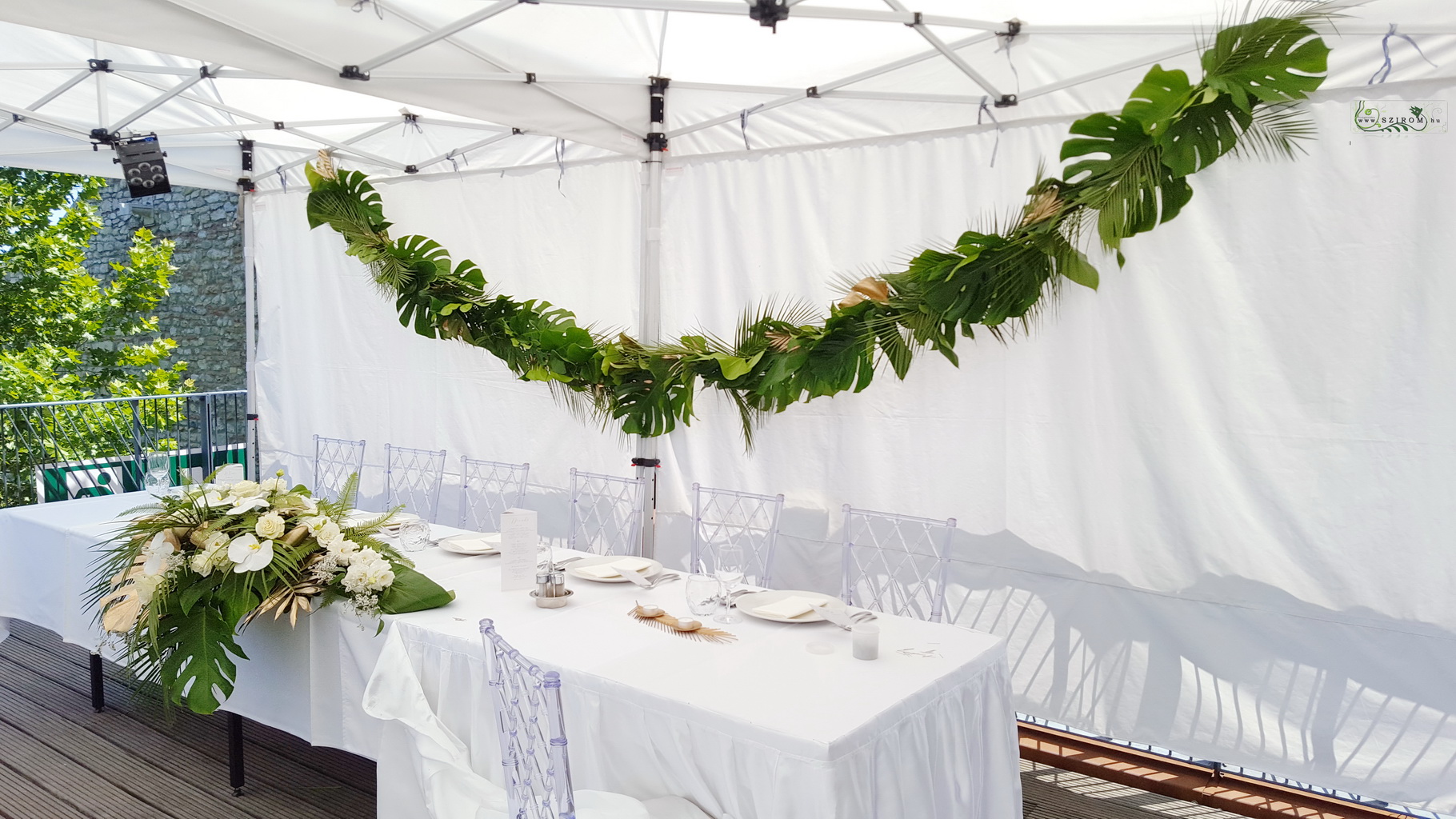 Blumenlieferung nach Budapest - Girlande mit Monstera und Palmblättern, Bazaar Eclectica Restaurant Budapest (grün, gold)