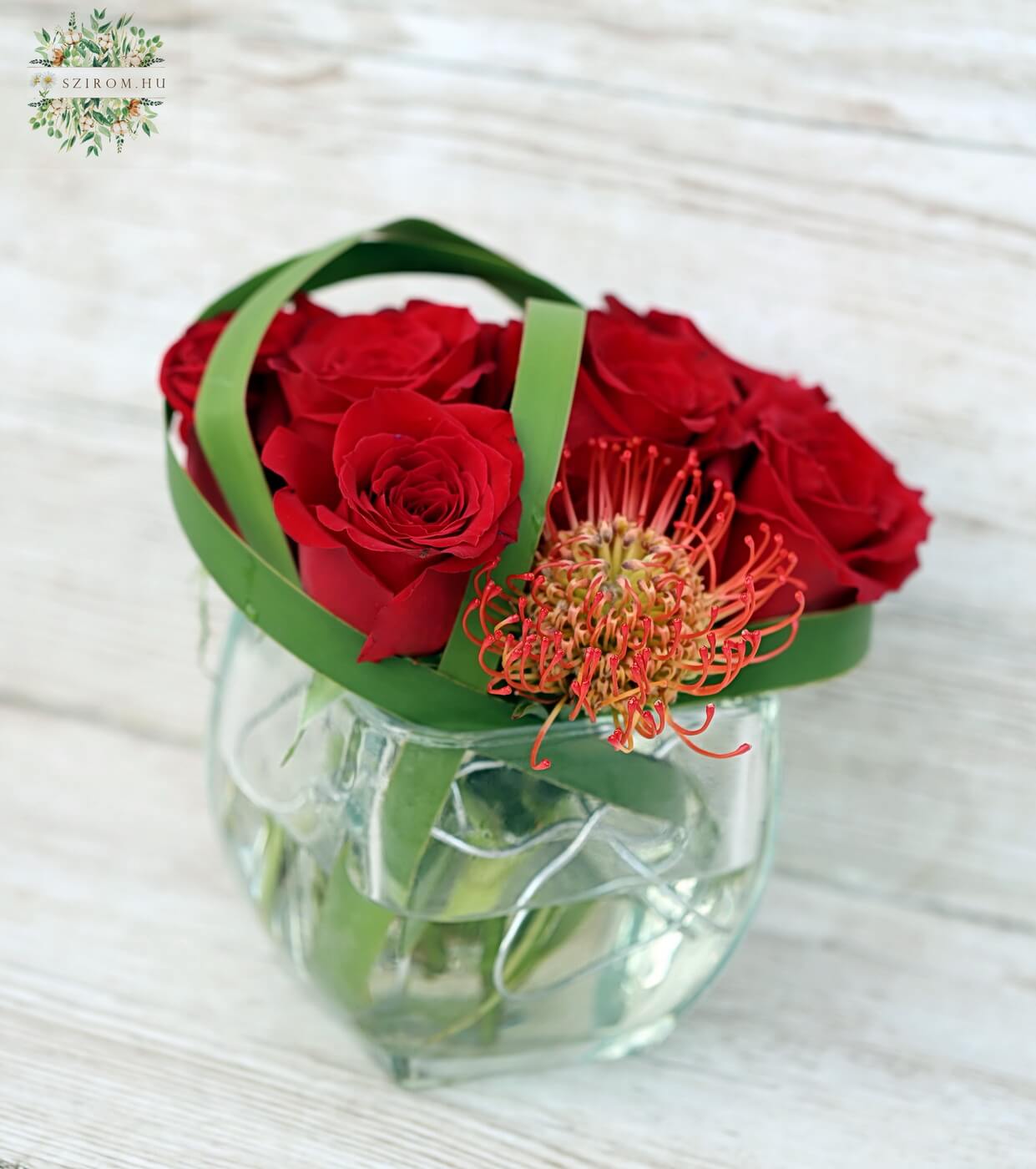 Blumenlieferung nach Budapest - Moderner Glaswürfel mit 7 roten Rosen und Leukospermum