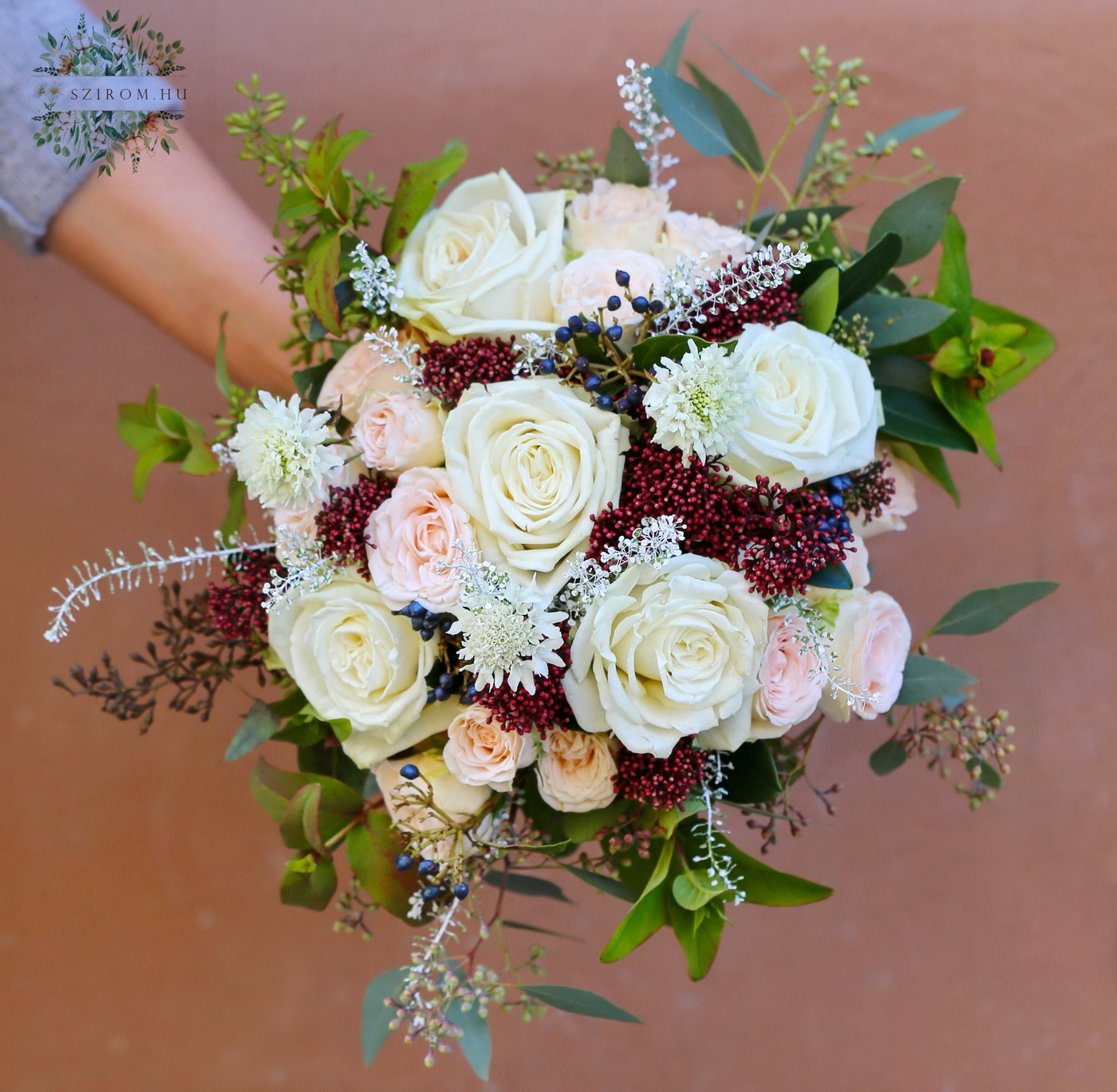 Blumenlieferung nach Budapest - Winterlicher Brautstrauß mit Rosen, Strauchrosen, Skimmie (weiß, pfirsichfarben, bordeauxrot)