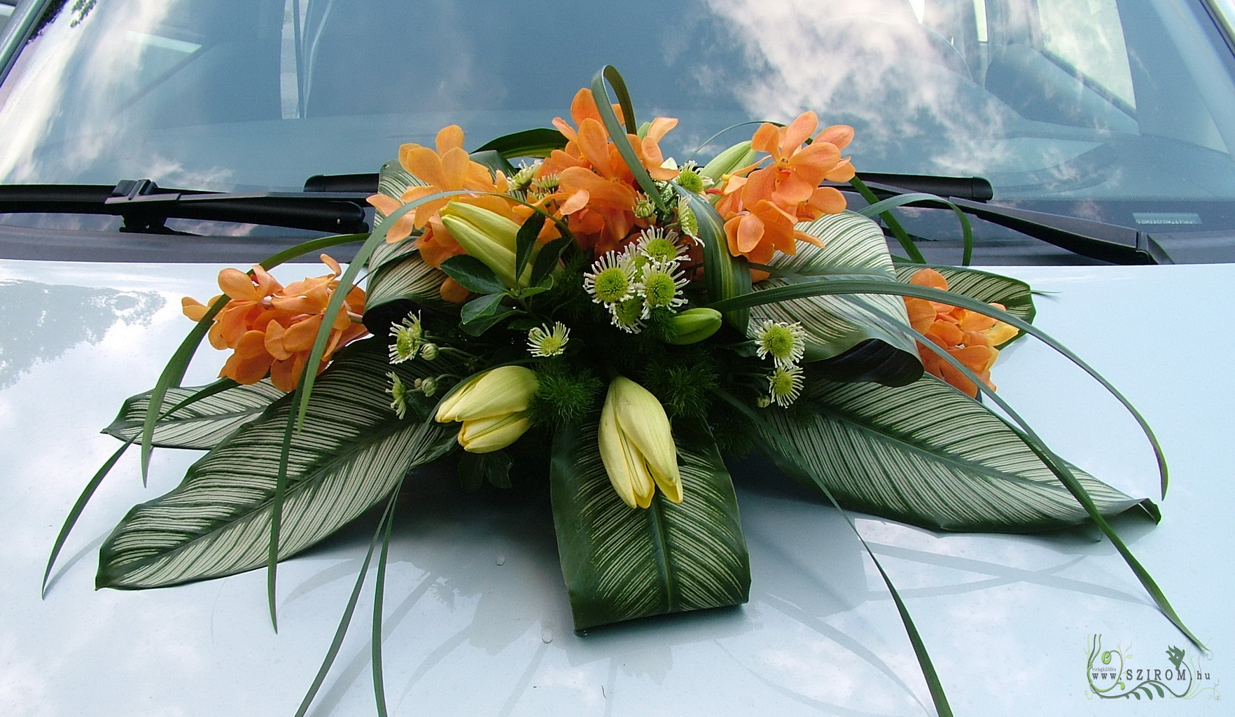 flower delivery Budapest - oval car flower arrangement with orchids (lily, chrysanthemum, orange, yellow, green)