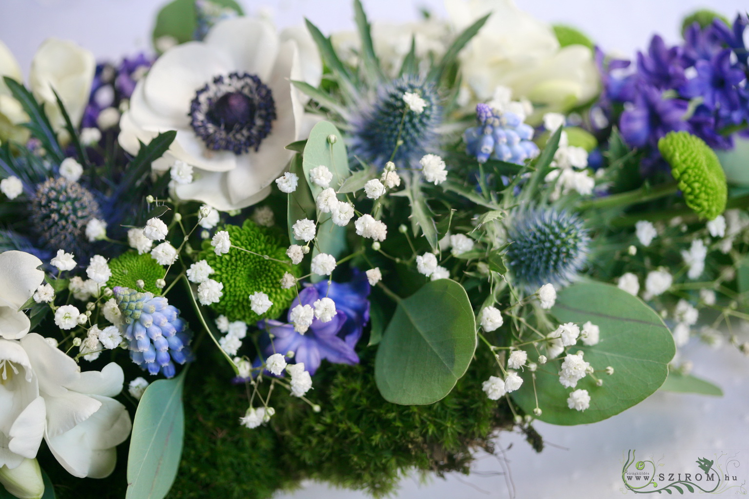 Virágküldés Budapest - Főasztaldísz tavaszi virágokkal, mohával, Mezzo Music (jácint, szellőrózsa, iringó, vadvirágok, frézia, fehér, kék), esküvő