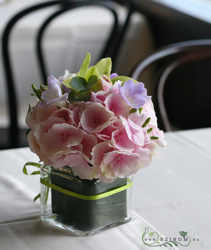 Virágküldés Budapest - Asztaldísz üvegkockában (hortenzia, frézia, orhidea, rózsaszín, lila, zöld)  Városliget Caffé Étterem, Budapest, esküvő